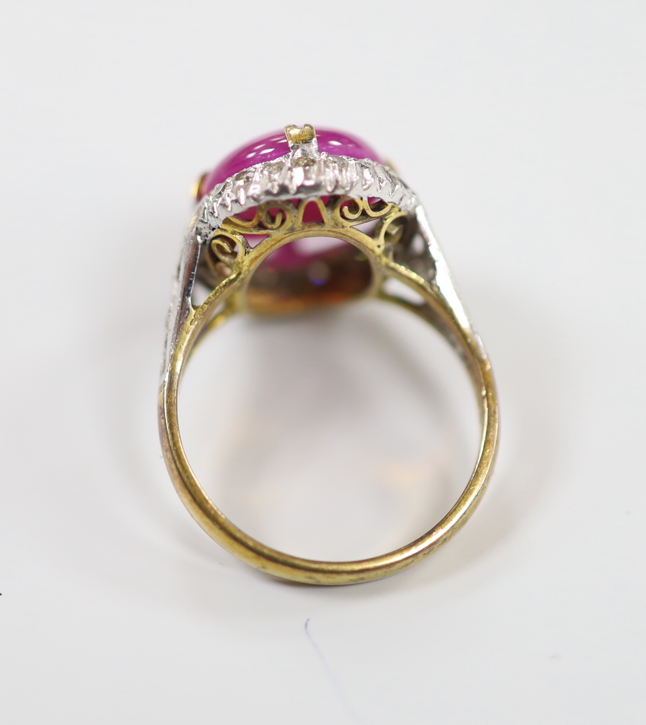 A yellow metal cabochon ruby and diamond chip set oval cluster ring, size M/N, gross weight 4.9 grams.